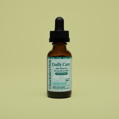 Bottle of Charlotte's Web Daily Care CBD Extract Oil on a beige background