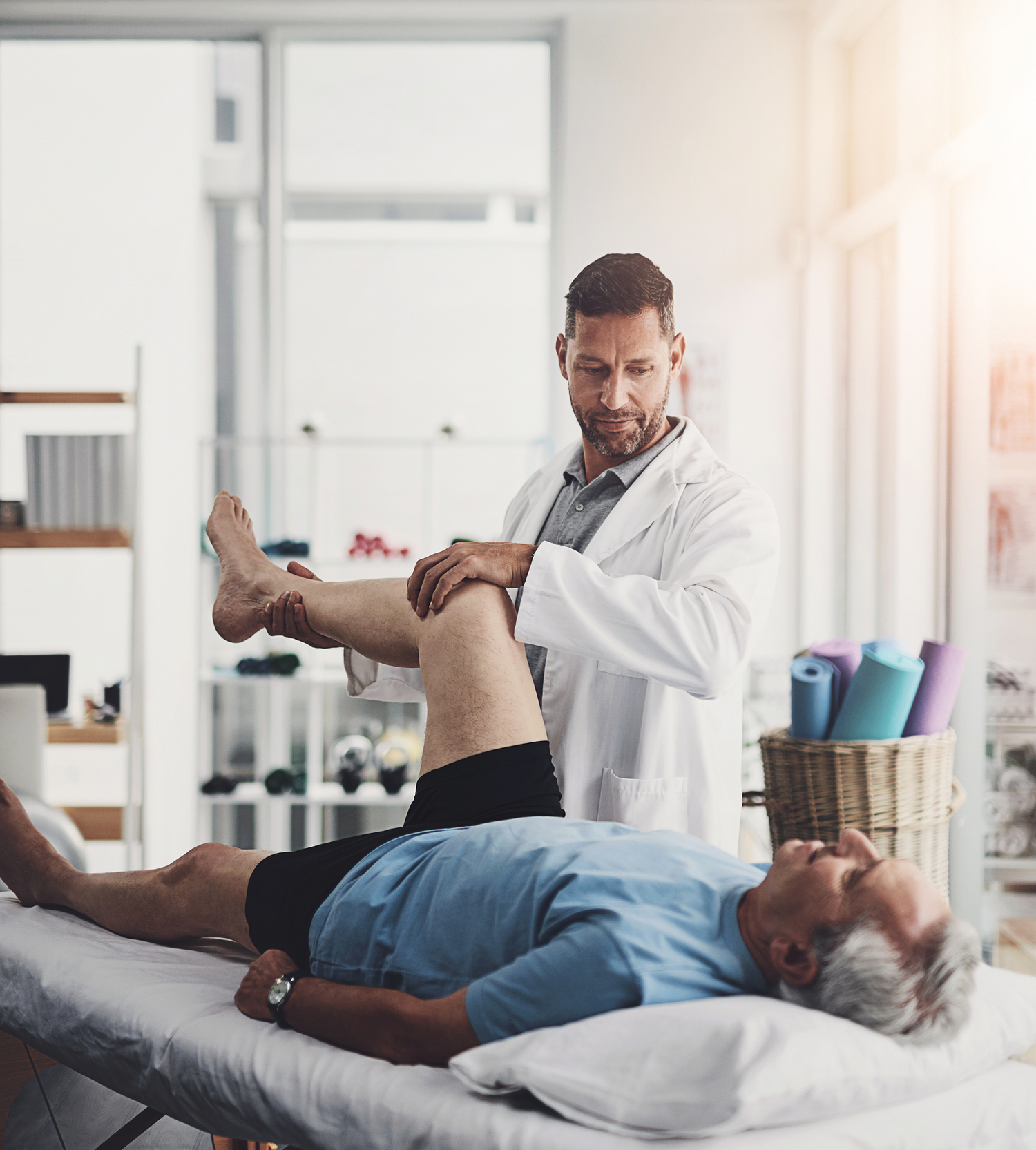 Physiotherapist examining a patient's leg in a clinical setting