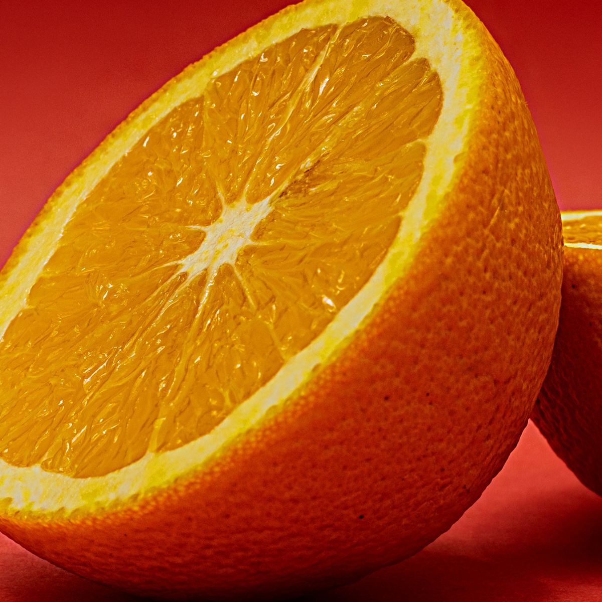 Close-up of a sliced orange on a red background